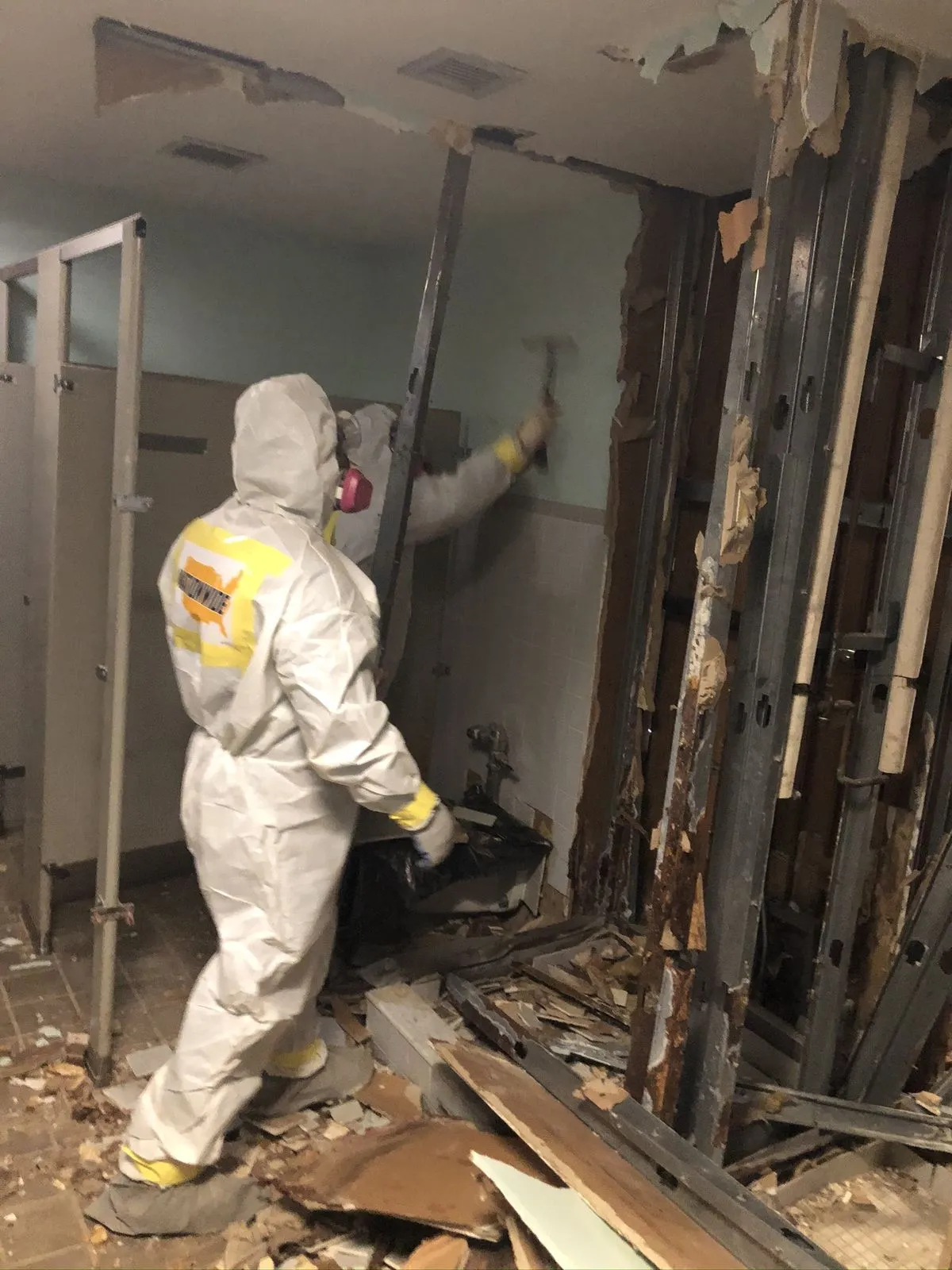 Professional mold remediation technician in protective equipment removing damaged materials during mold cleanup in Everett, WA.