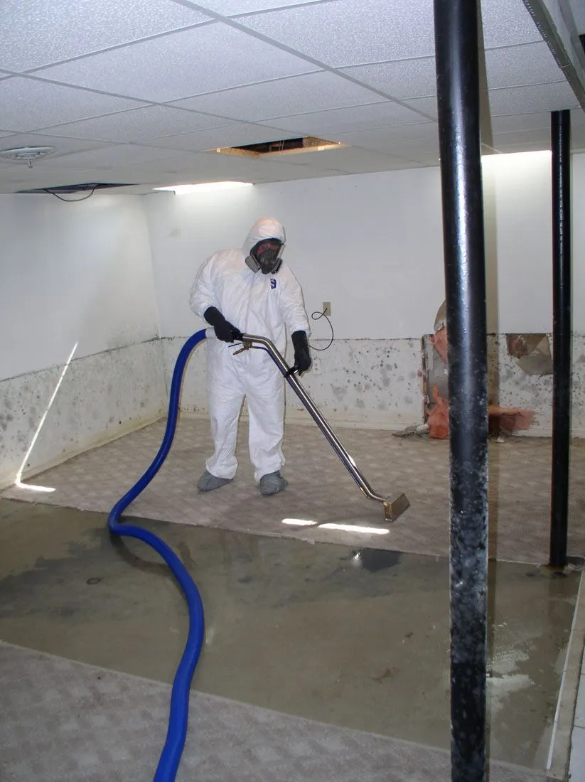 Professional water damage technician using extraction equipment in a flooded commercial property in Everett, WA.